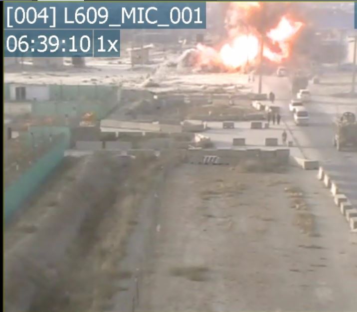 A security camera high angle over an Afghan townscape showing an explosion on a street.