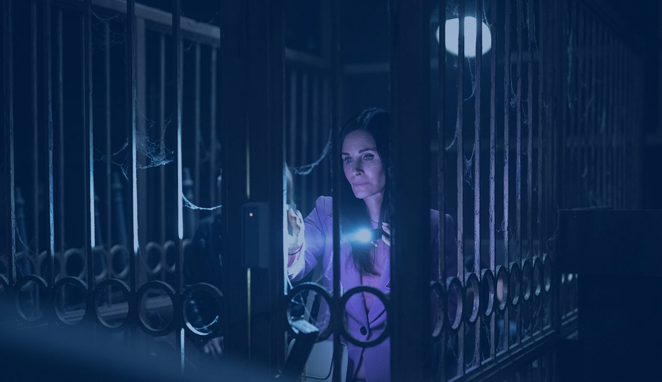 A woman concentrates as she pauses at gate in a set of tall railings.