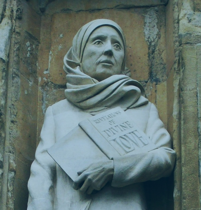 A statue of a Medieval women wearing a headscarf, and holding a book inscribed: revelation of divine love.o