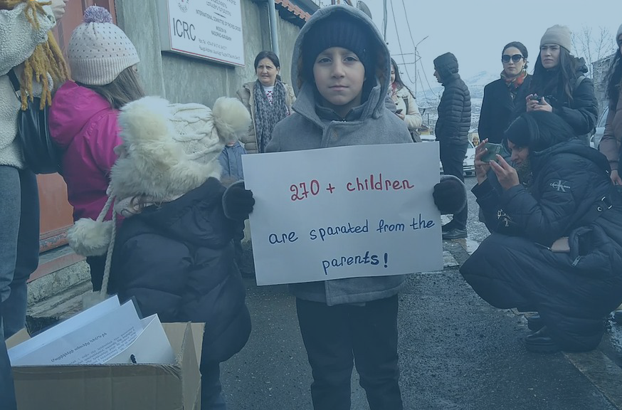 A child protestor holds a placard at a demonstration