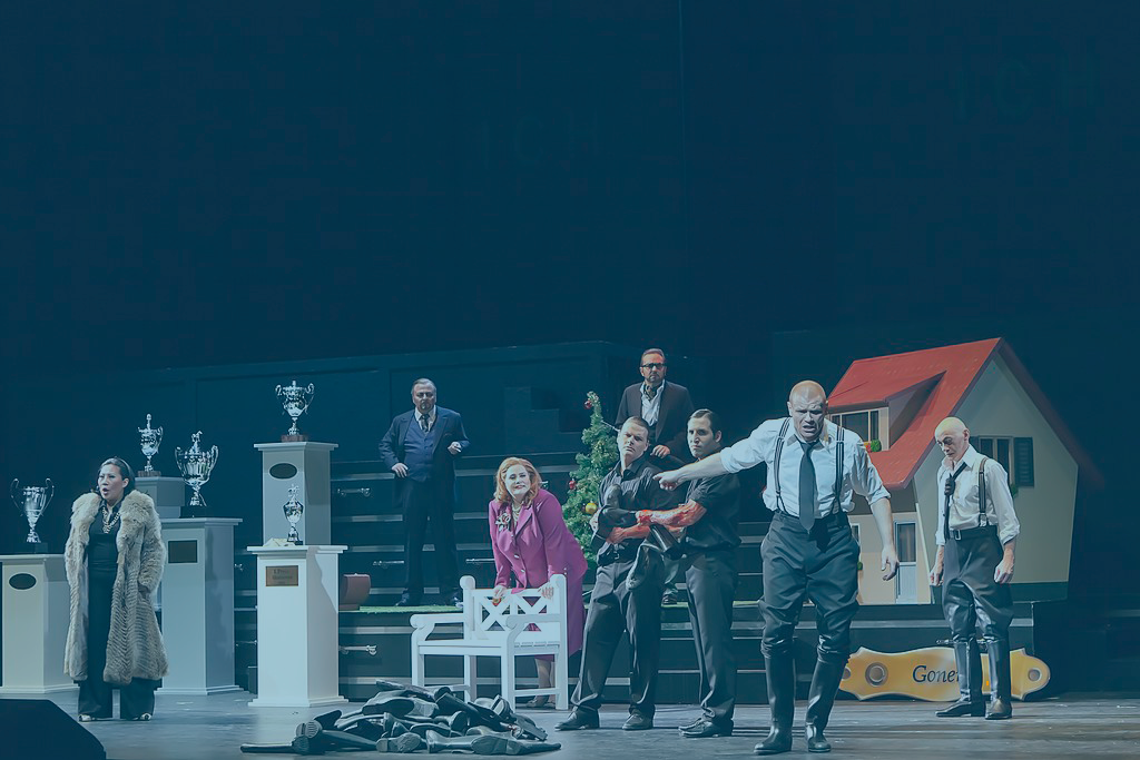 A modern staging of King Lear has the cast across the page. King Lear is front of stage gesturing while the others look on