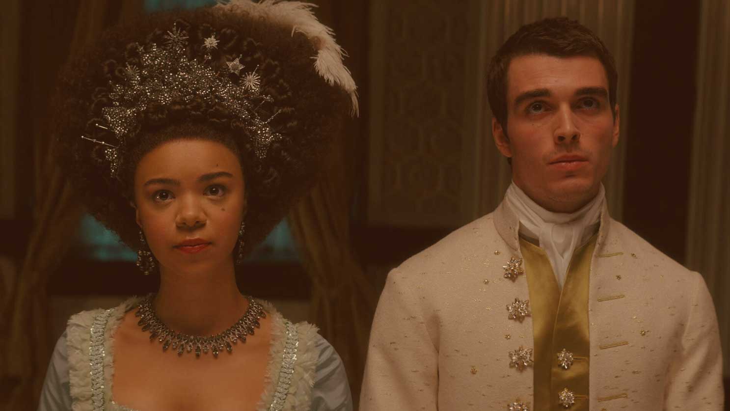 A regency queen and king stand beside each other looking pensive.