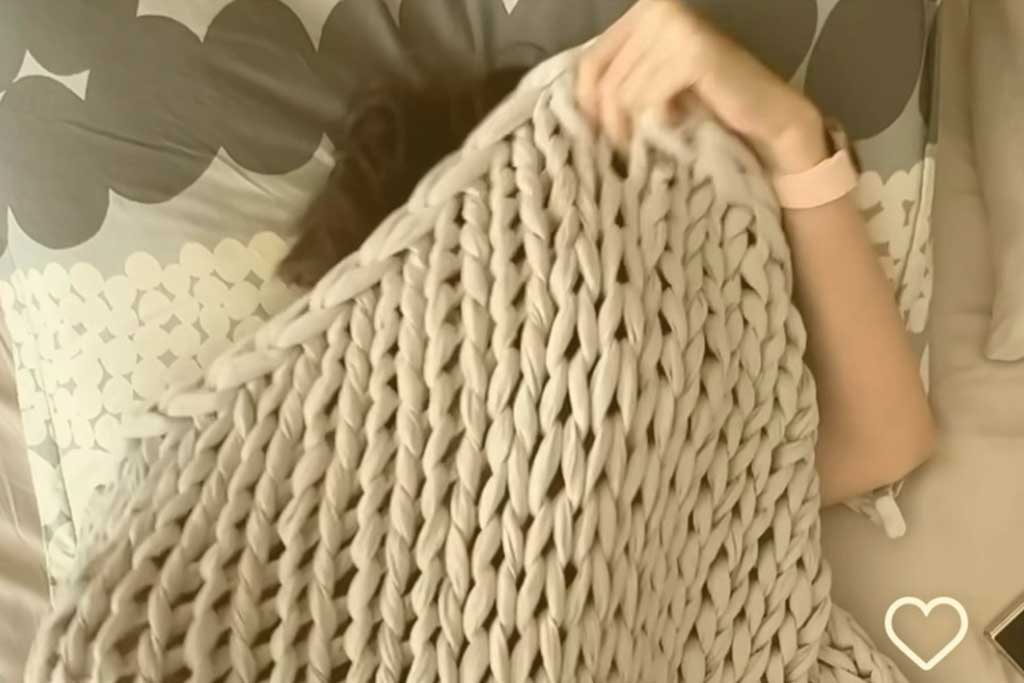 a sleeper pulls a blanket up over their head.