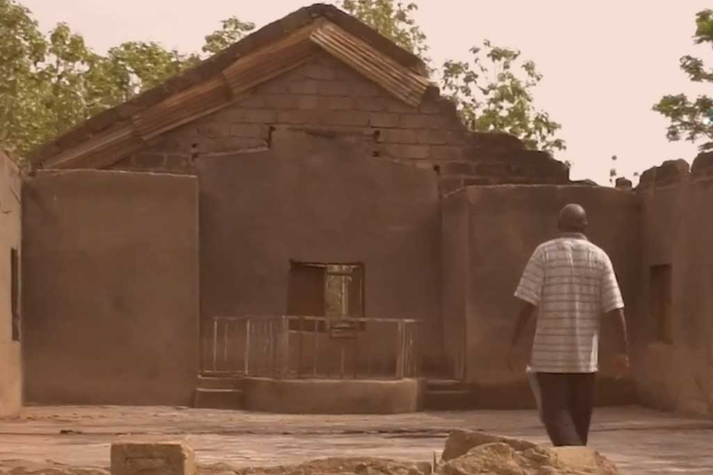 A person stands in the burn out shell of a church in Nigeria.