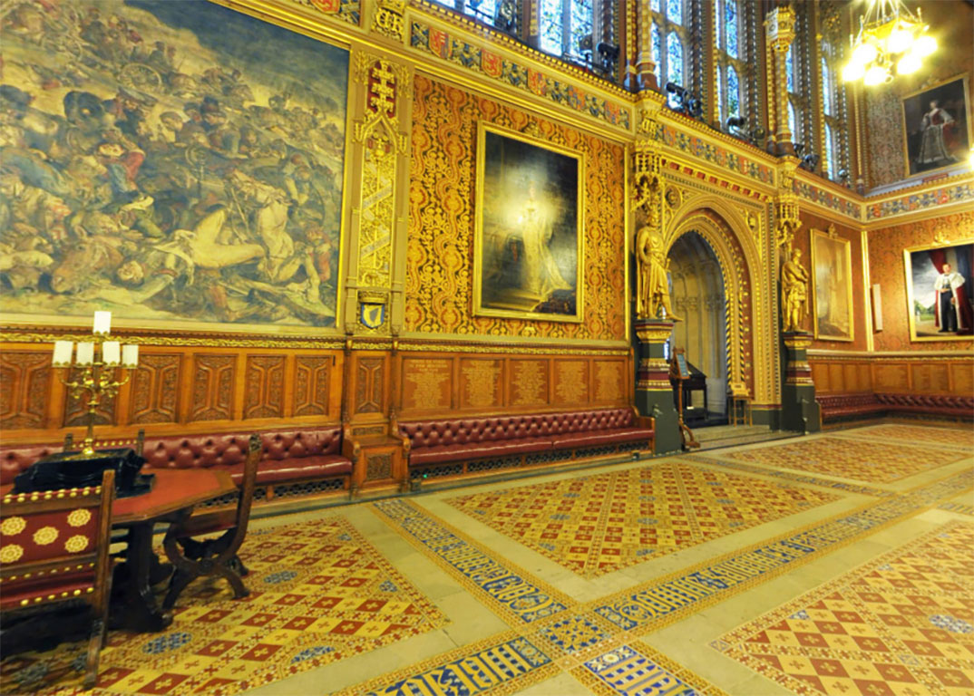 A grand highly dercorated hall in the neo-gothic style, with encaustic tiles in the foreground.