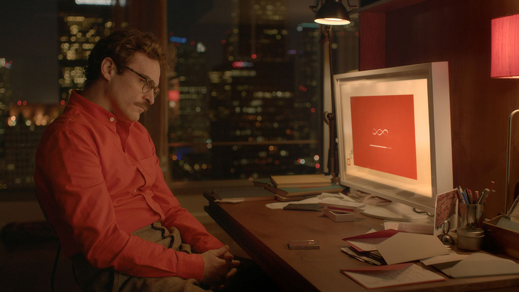 A man in a red shirt slumps in his seat while a computer screen shows a dialogue screen