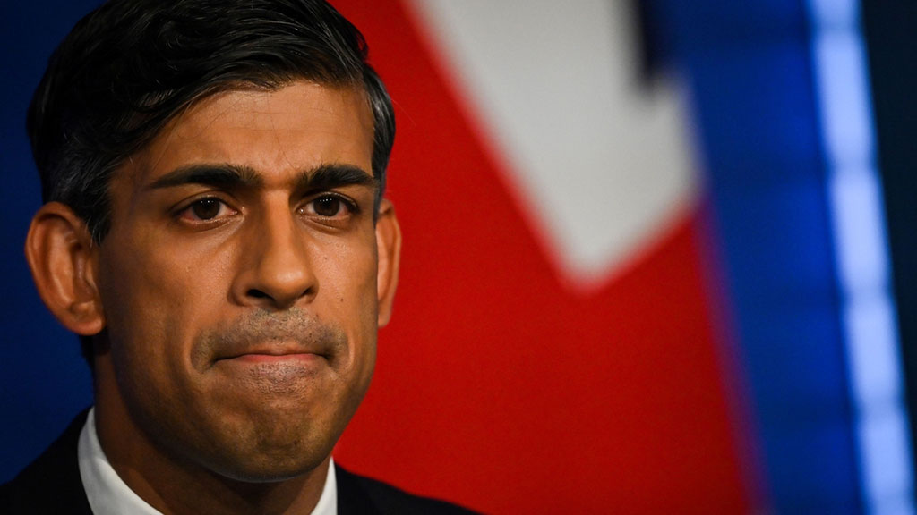 A cropped image of the face of RIshi Sunak with colours of a flag behind him