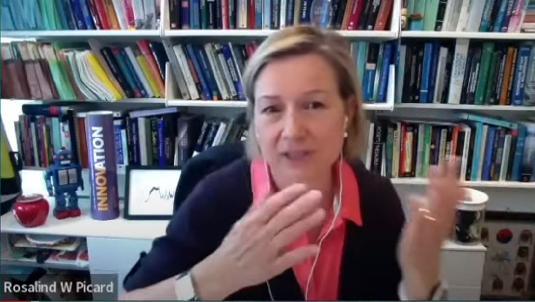 a woman at a desk video call gestures with her hands to make a point.