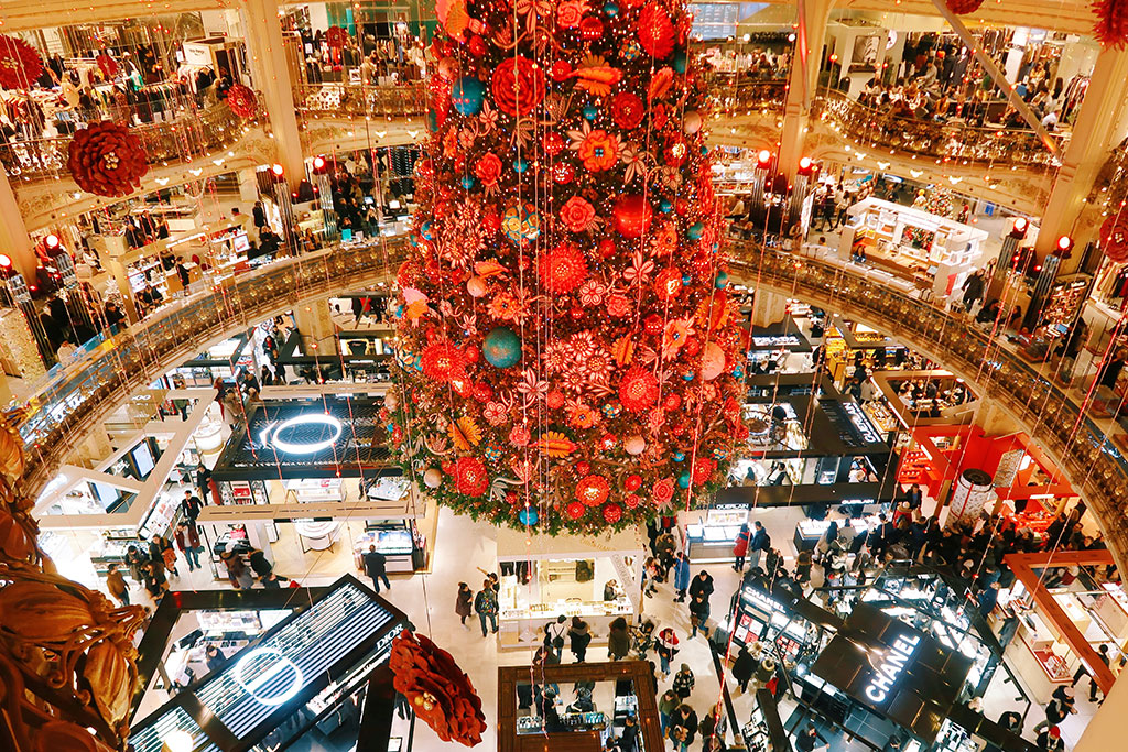 Looking down a red shiny christmas tree in the centre of a department store gallery.