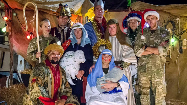 Dressed in camouflage uniforms and makeshift costumes, soldiers create a nativity scene