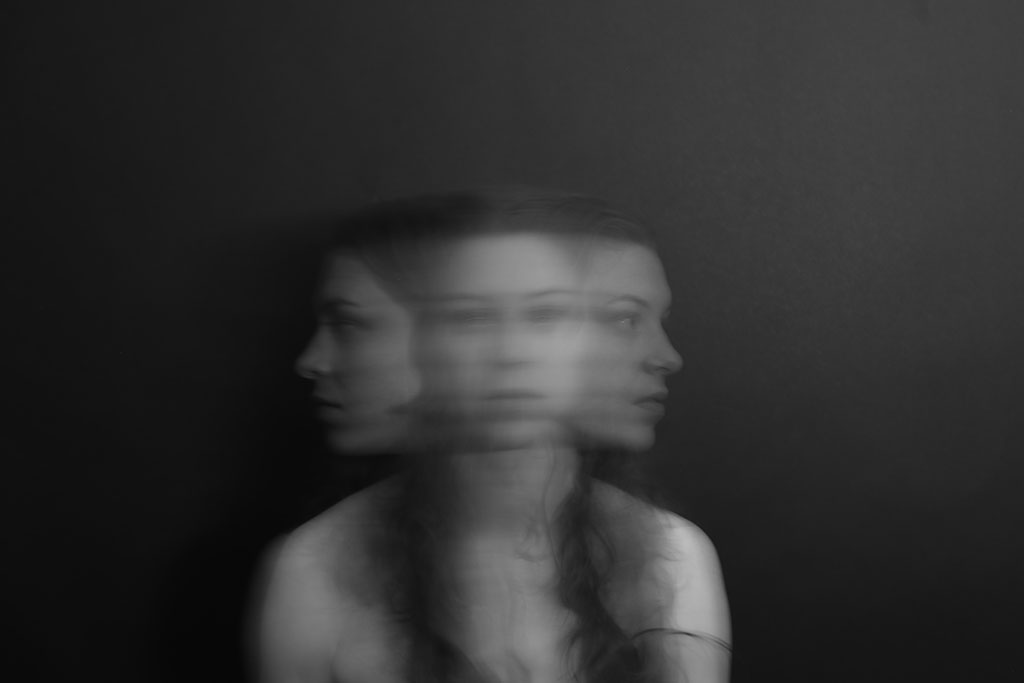 A blurred multiple exposure shows a woman turning her head from side to side.