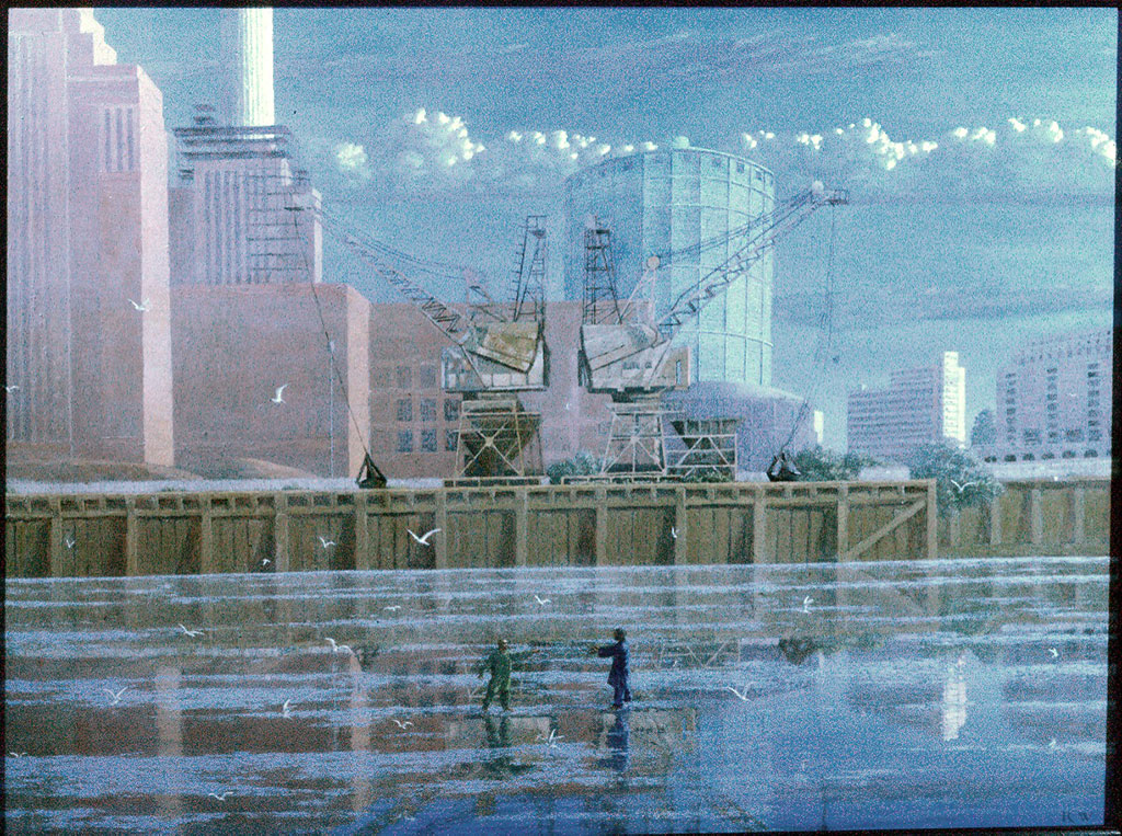 Figures hover on a river foreshore against the background of a dock and power station chimneys
