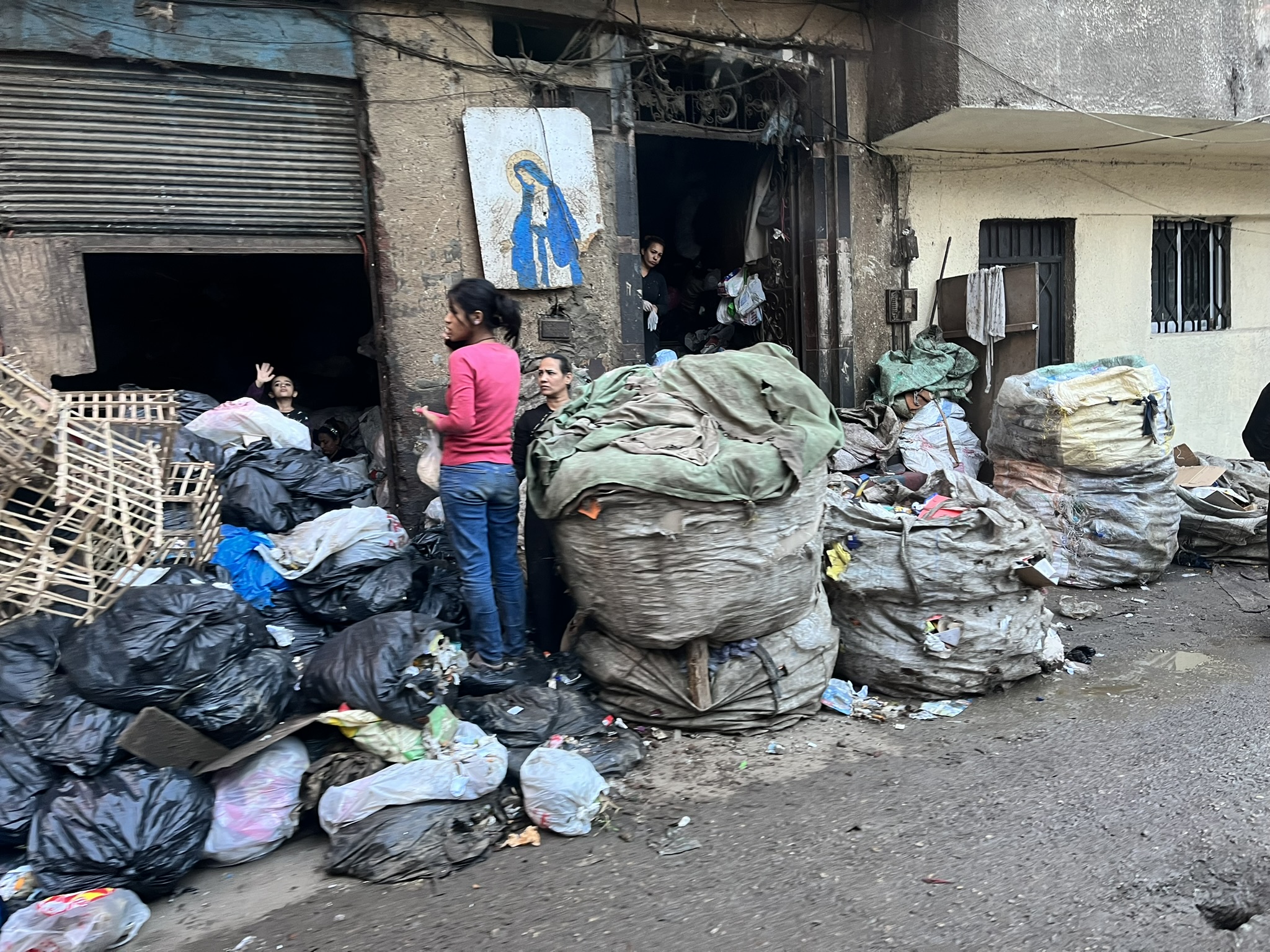 A child walks between bags of rubbish in a pile