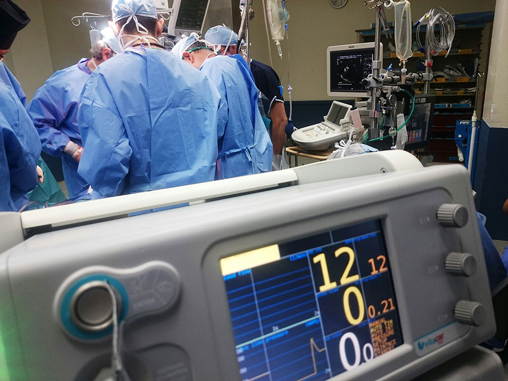 While surgeons operate in the background a digital display shows numbers in the foreground