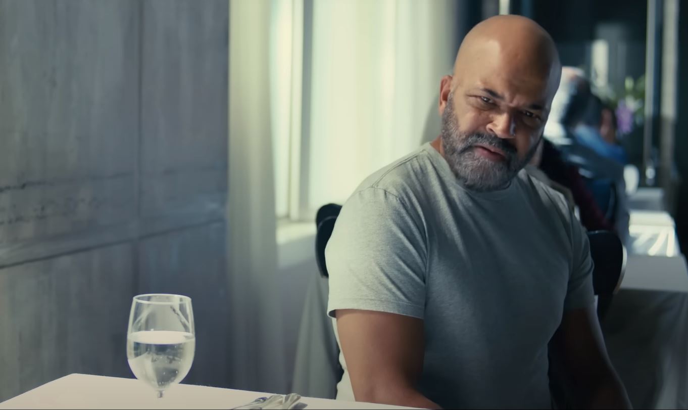 A man sitting at a restaurant table turns and looks aside.