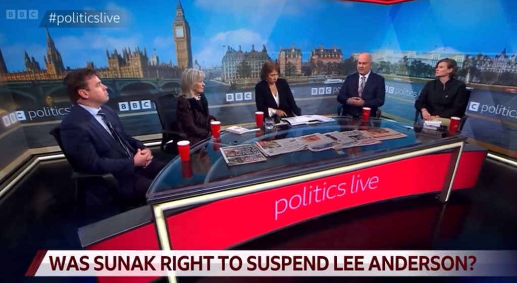 A TV roundtable discussion with five people against a backdrop of Parliament.