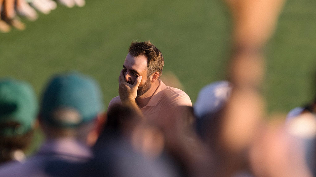 A golfer cups his face as he realises he has won.