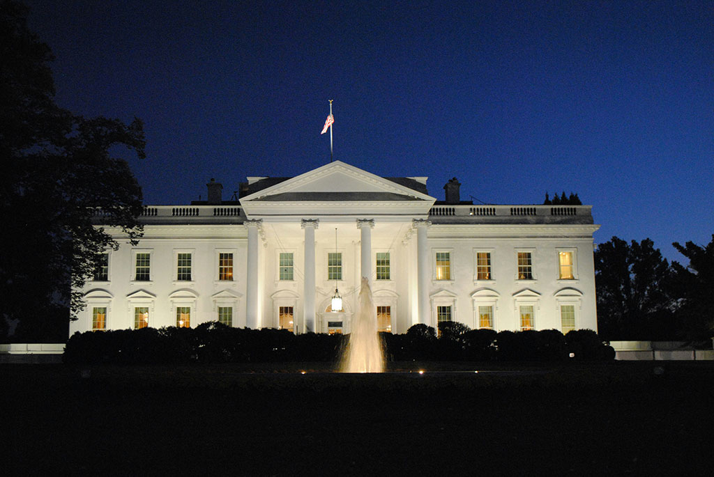 The White House illuminated against the night sky.