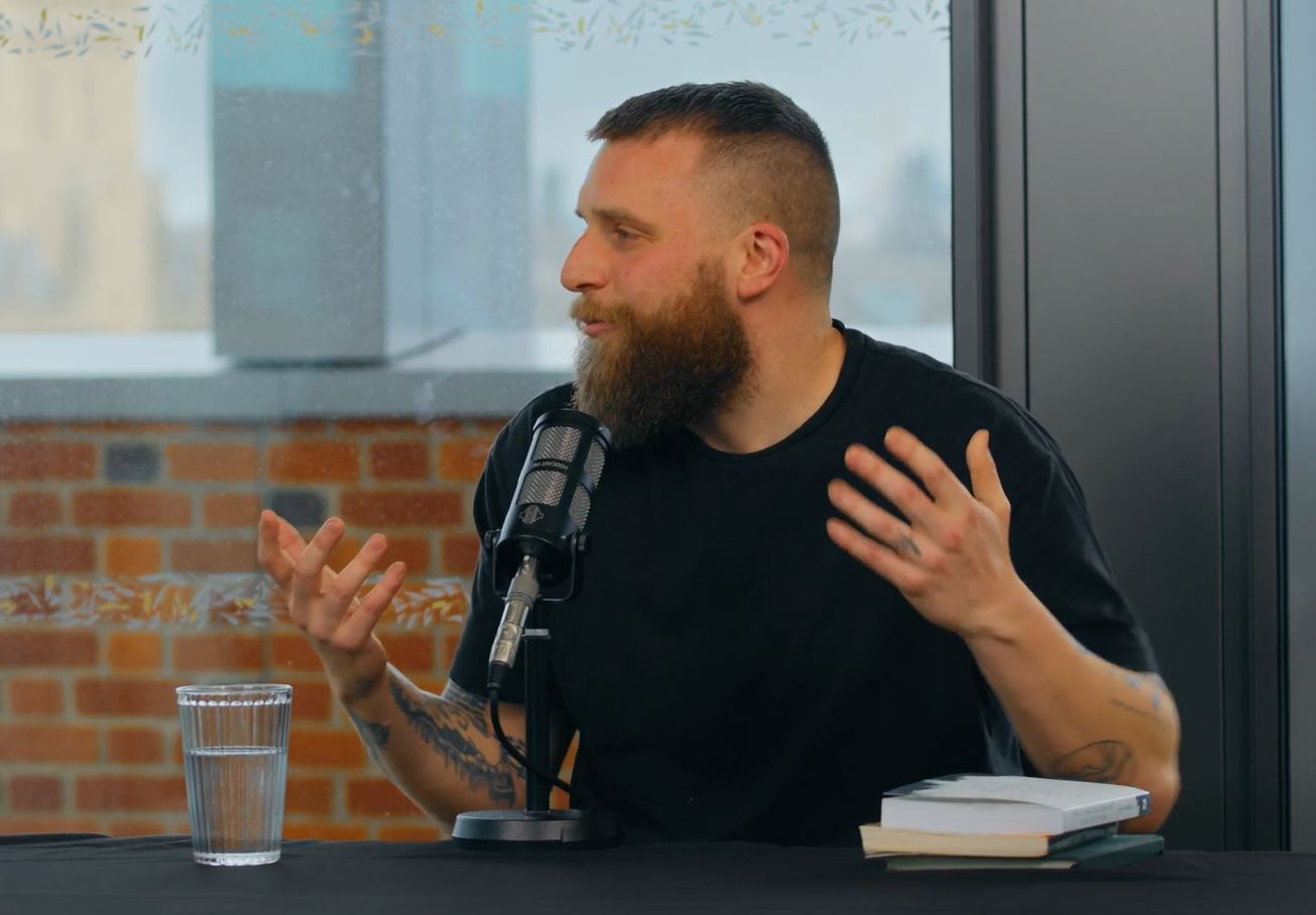 A guest on a podcast, gesture in front of a microphone.