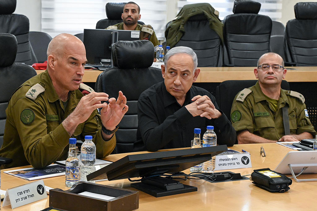 Between two generals wearing camouflage uniforms, a man in a black shirt listens.