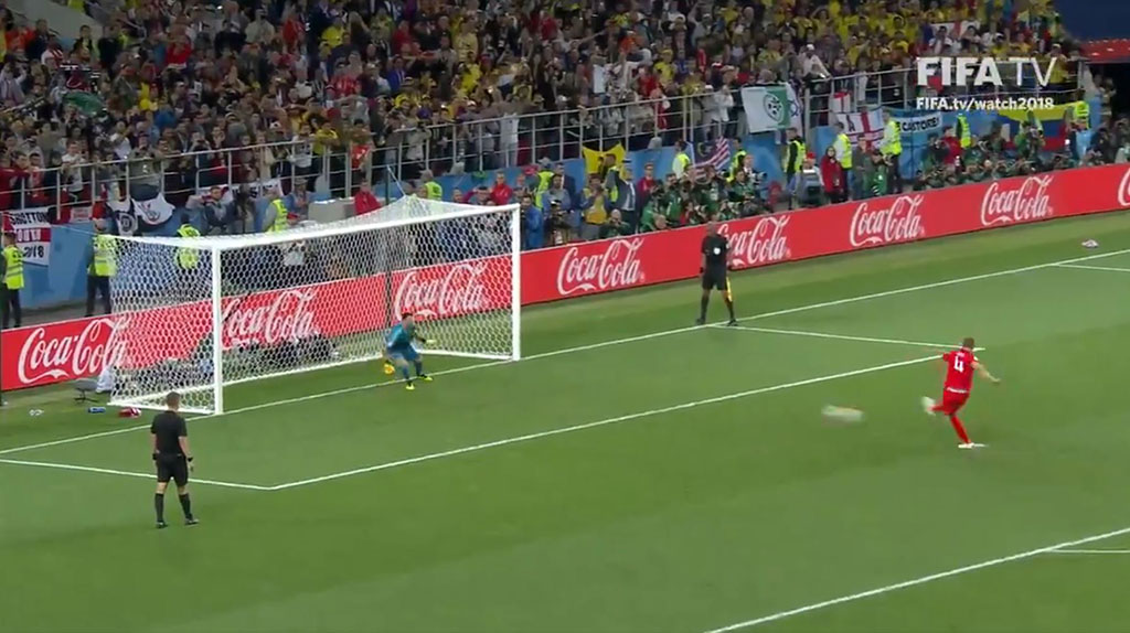 A footballer takes a penalty kick.