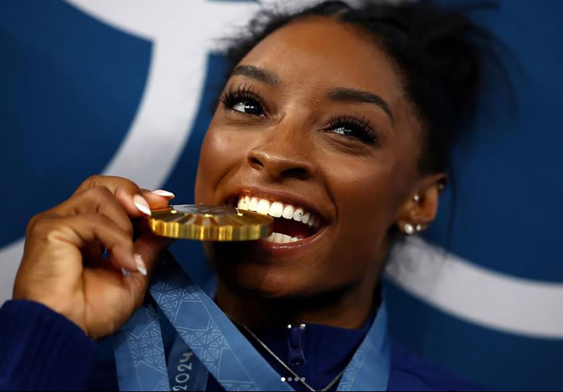 A gold medallist bites her medal.