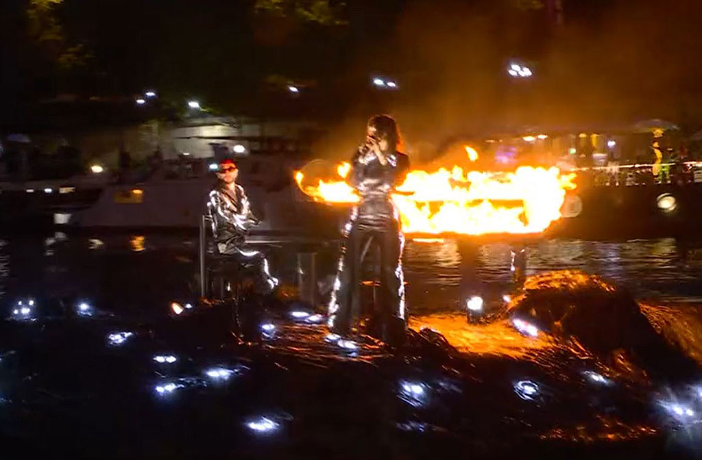 A floating stage bears a flaming piano and singer standing at a mic.