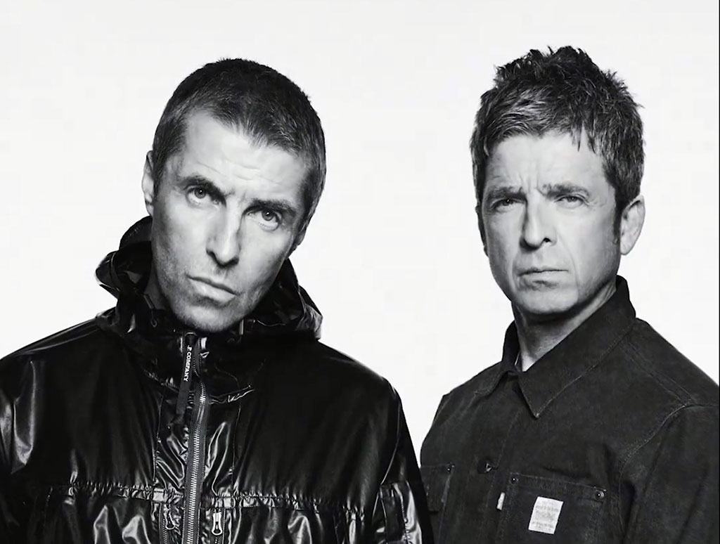 Two middle age rock star brothers pose for the camera in a black and white picture