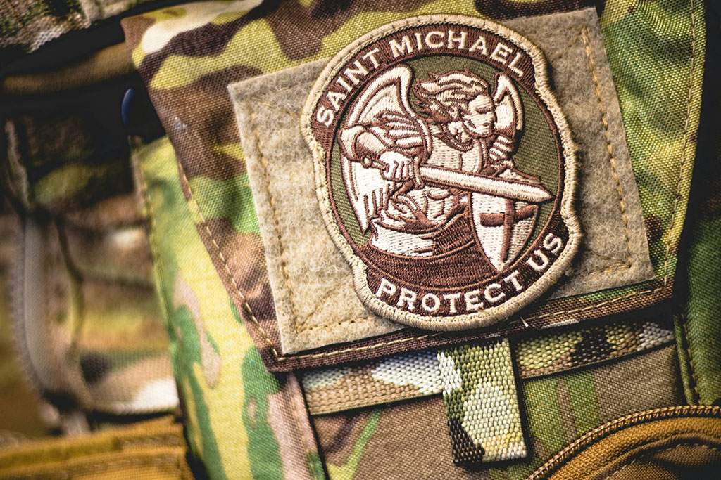 A patch depicting a angel in armour, wielding a sword, on camoflague uniform.
