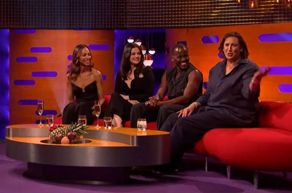 On a TV chat show, guests look to one of their own talking to the audience. 