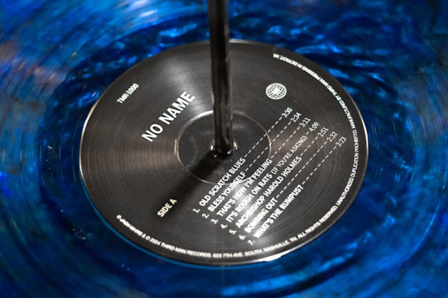 A close-up of the black label of a blue vinyl record