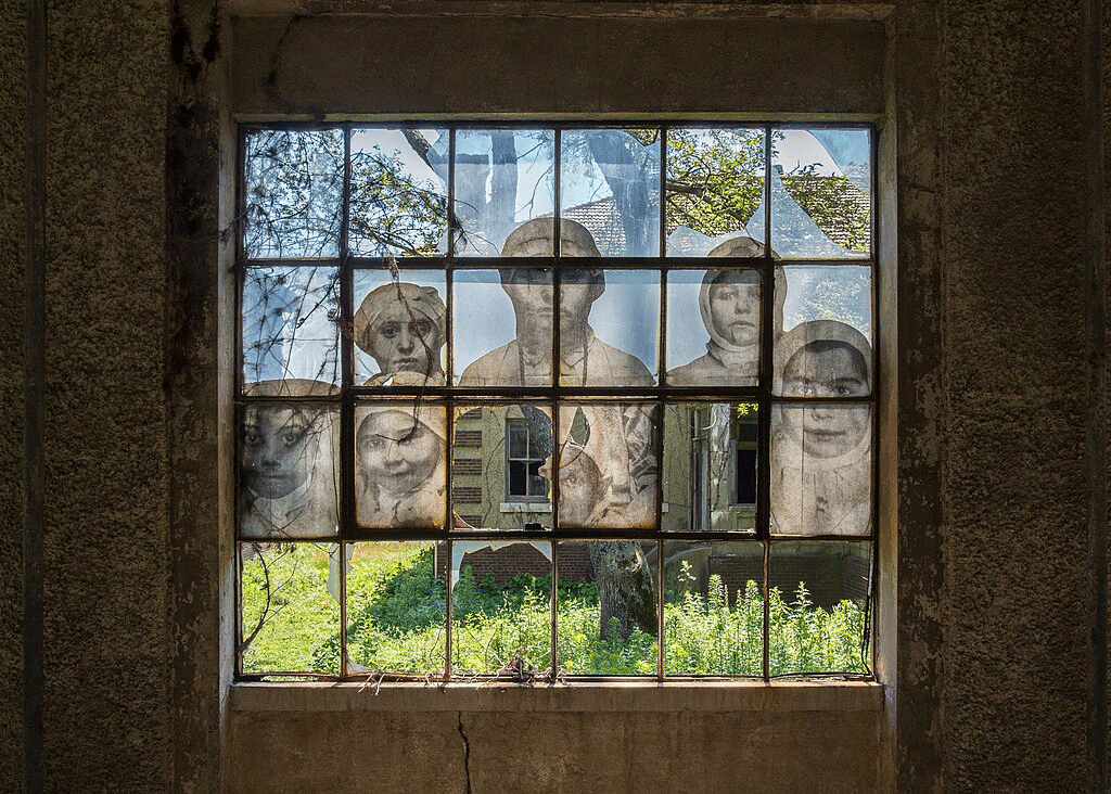 a multi-paned window mural shows people while amid it are broken window panes.