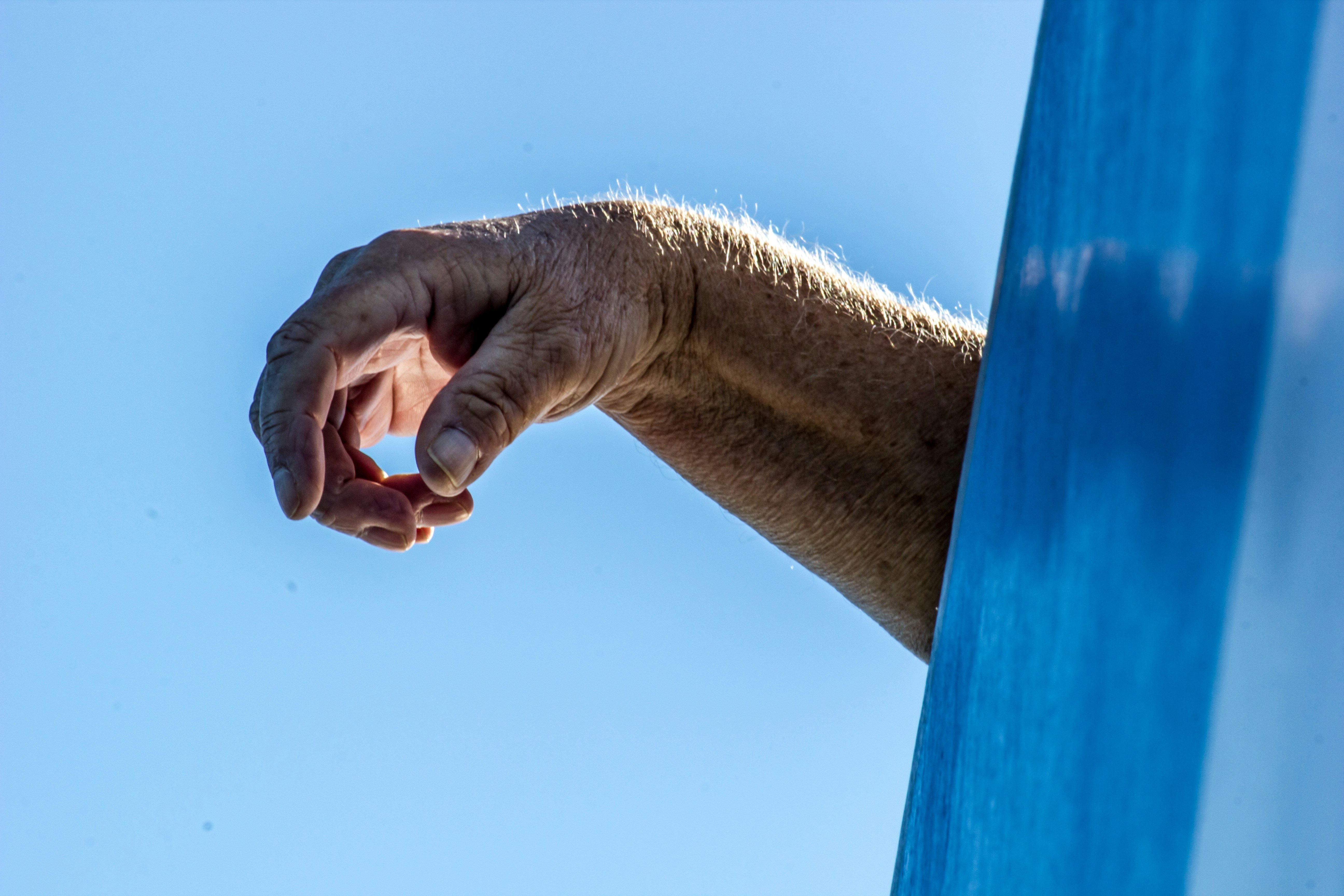 A hand drapes over the side of an object out of shot.