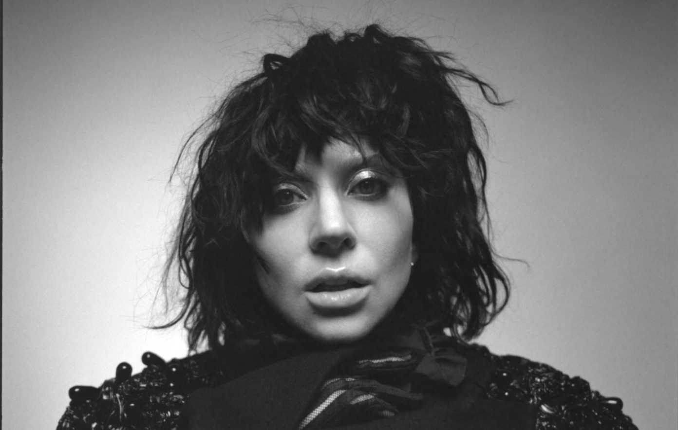 A black and white photo of a woman about to open her mouth to sing.