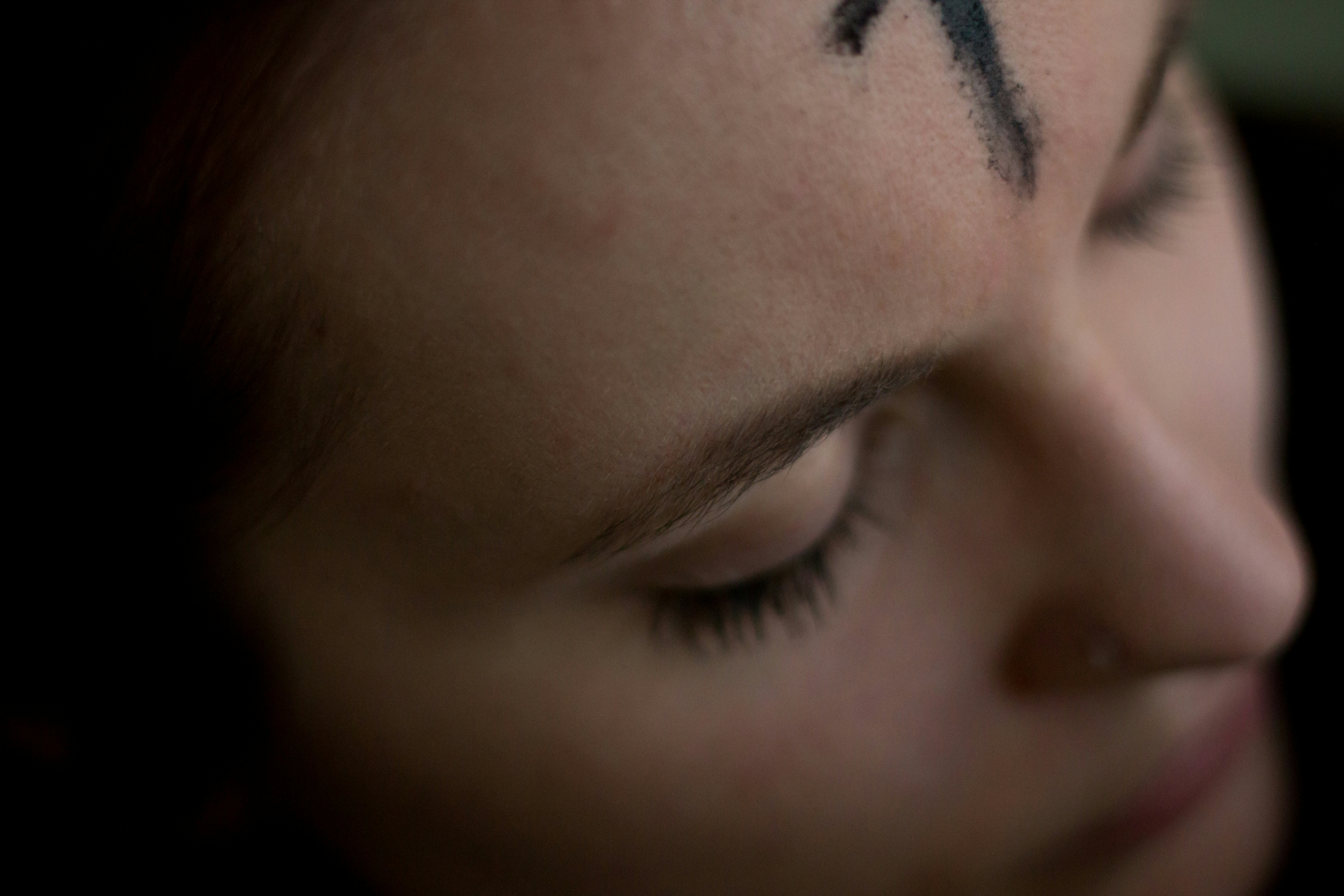 A close up of a forehead bearing an ash cross marked on it.