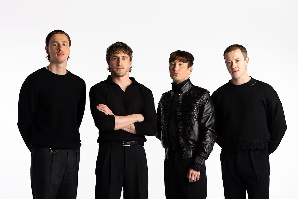 Four actors dressed in black stand together