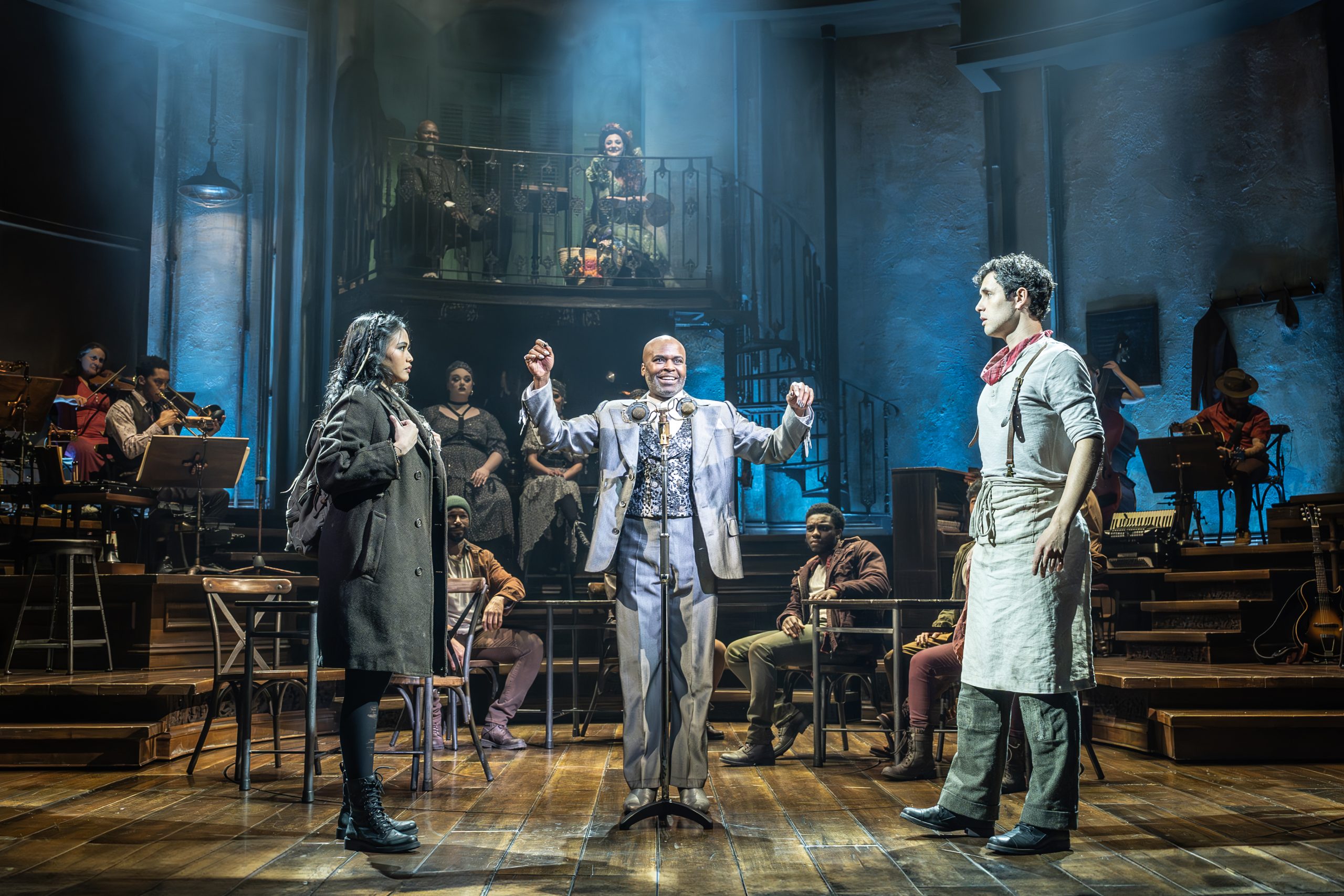 A theatrical staging shows a couple seperated by a man standing between them.