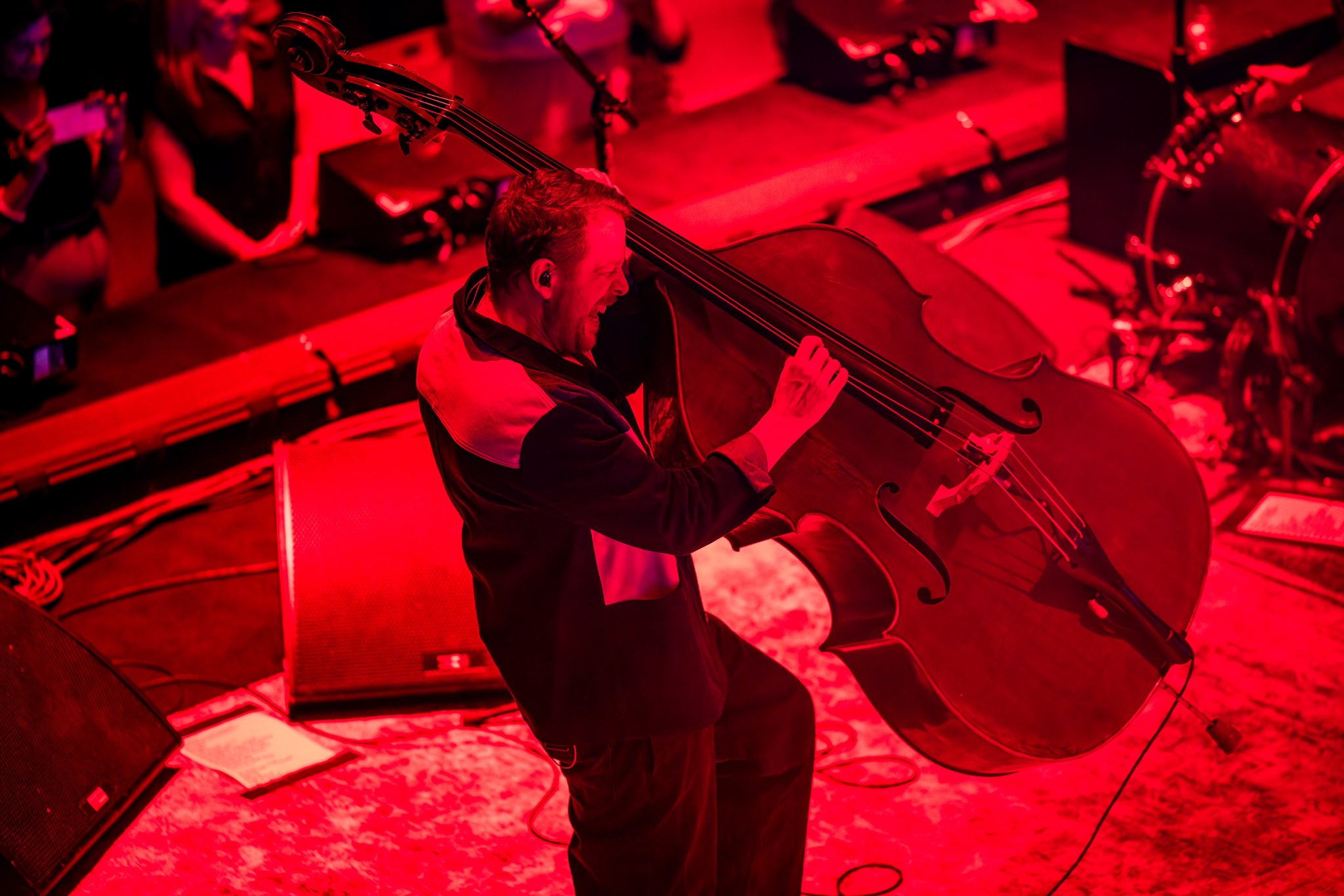 A bassist hauls a double bass of its base as he plays it.