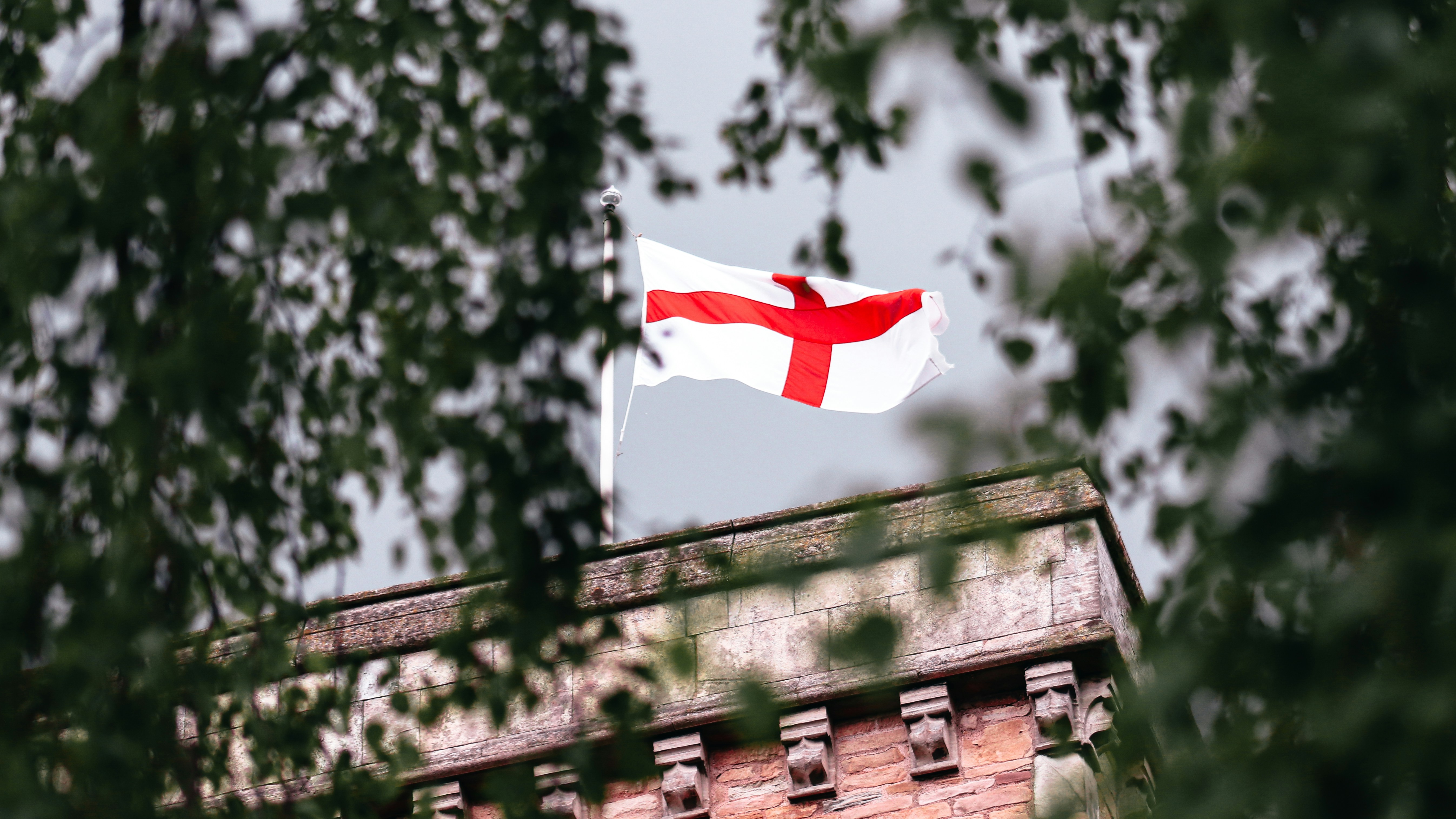 A St George's Cross flag flutters on a tower.