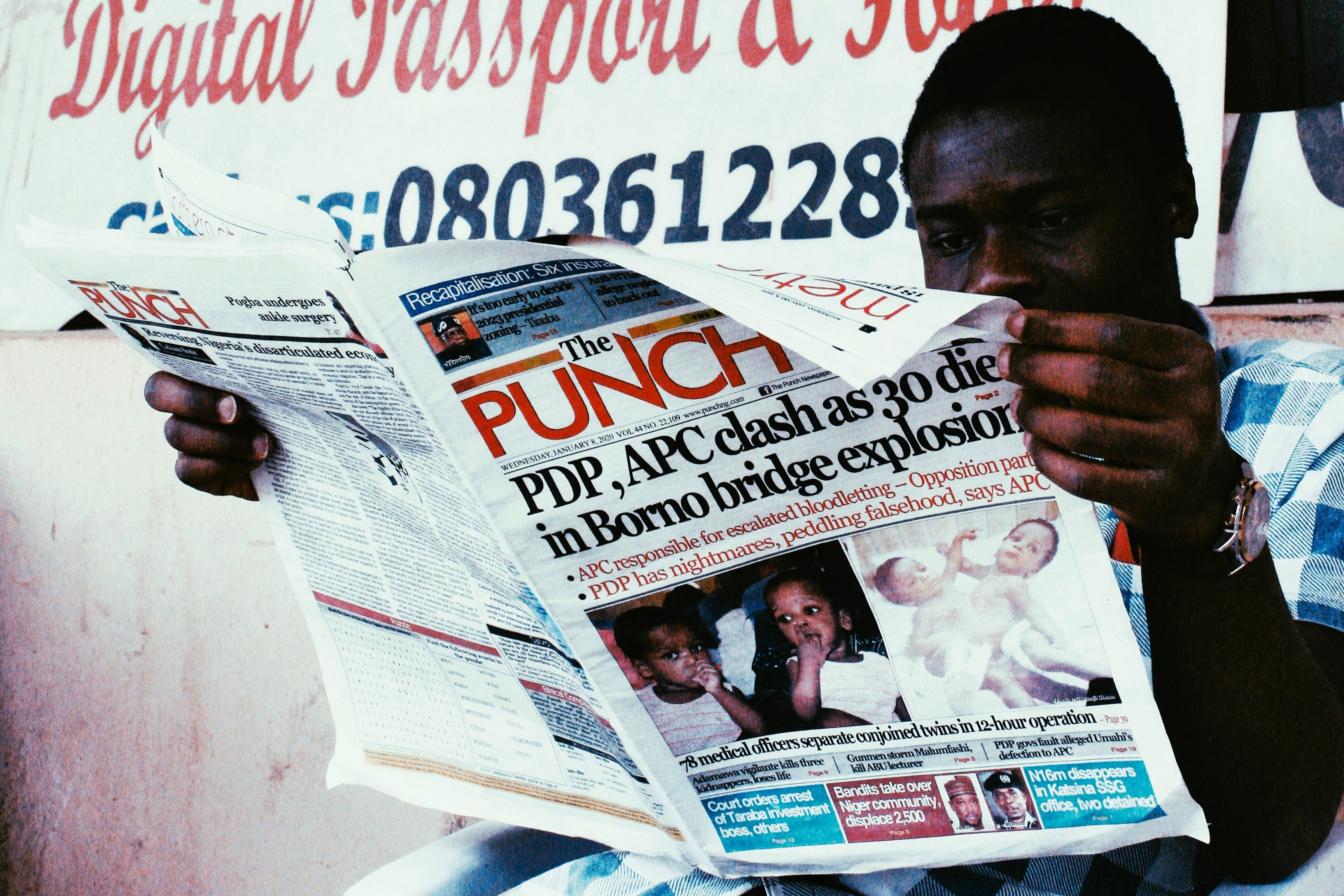 A man reads a newspaper called The Punch.