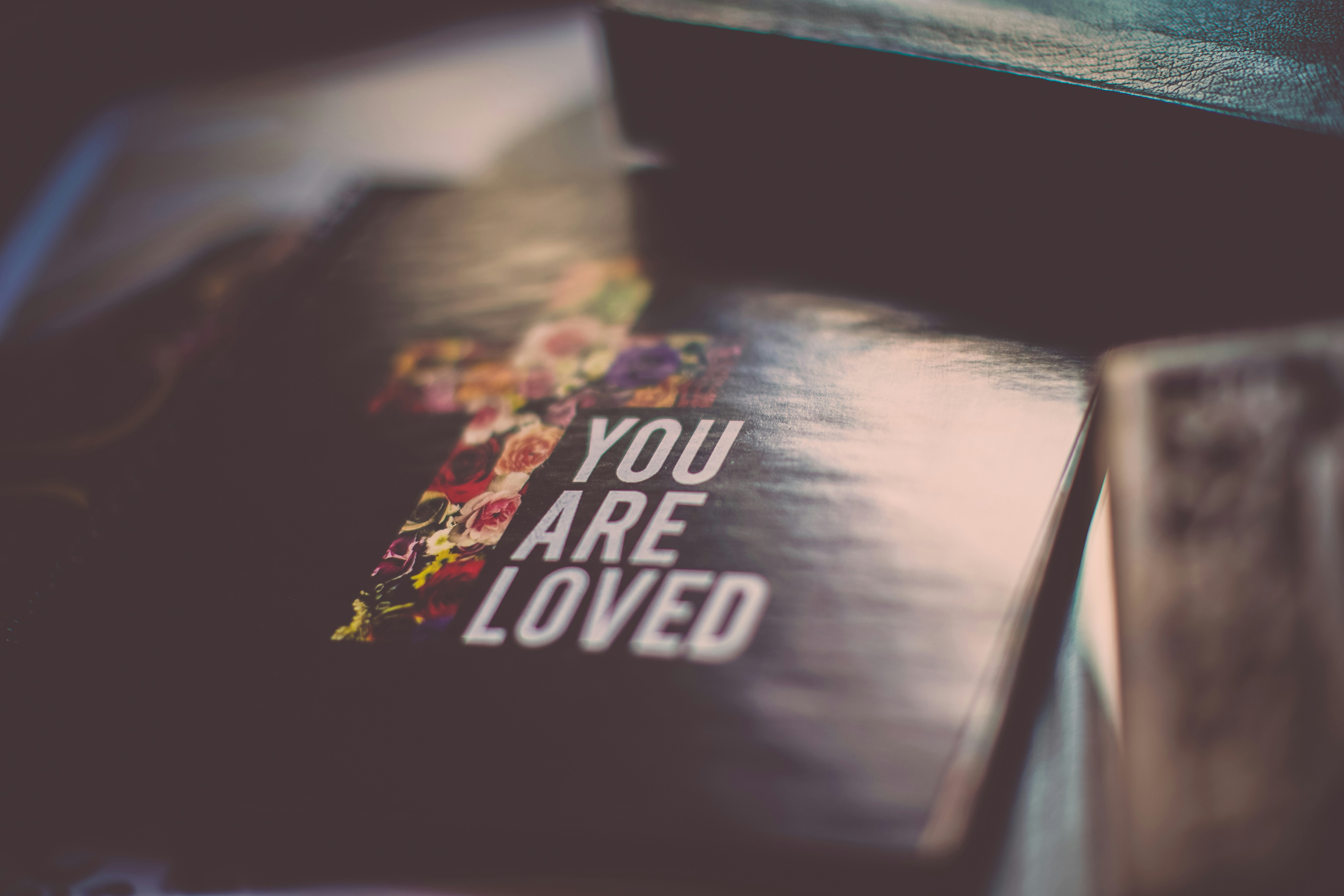 A cover of a book show a cross and the title 'You are loved'.