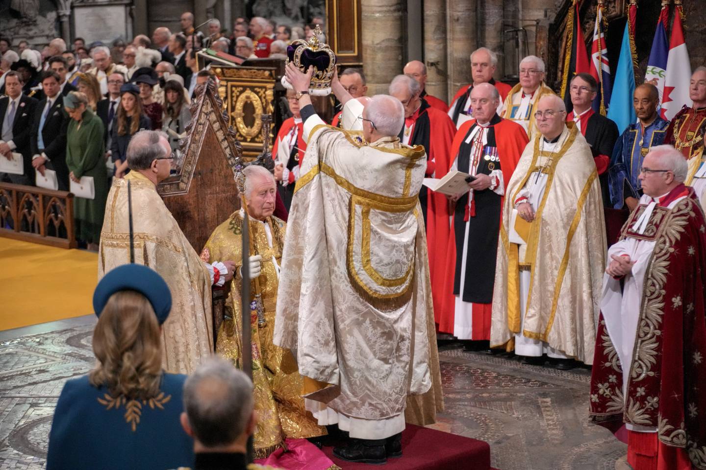 An archbishop raises a crown about the head of King Charles.