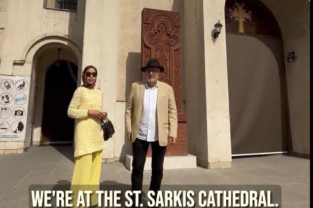A couple stand on the steps of a cathedral in Iran.