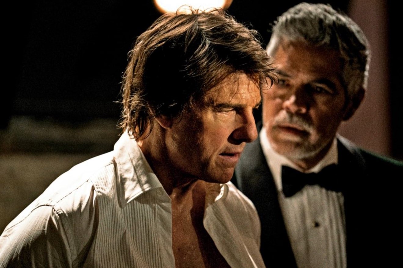 Tom Cruise playing Ethan Hunt in an open necked shirt looks perplexed.