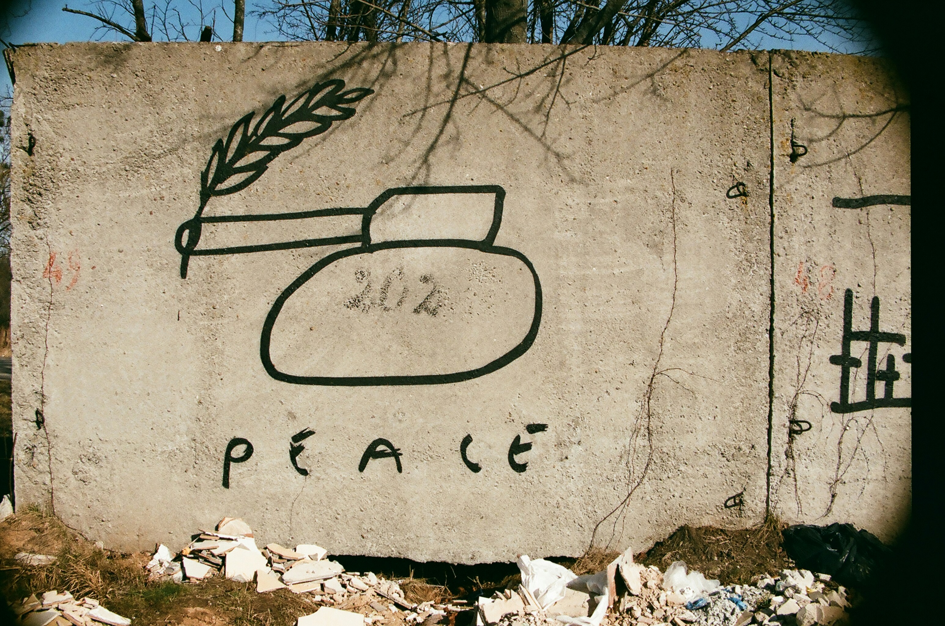 Graffiti of a tank with a peace laurel coming out of its barrel.