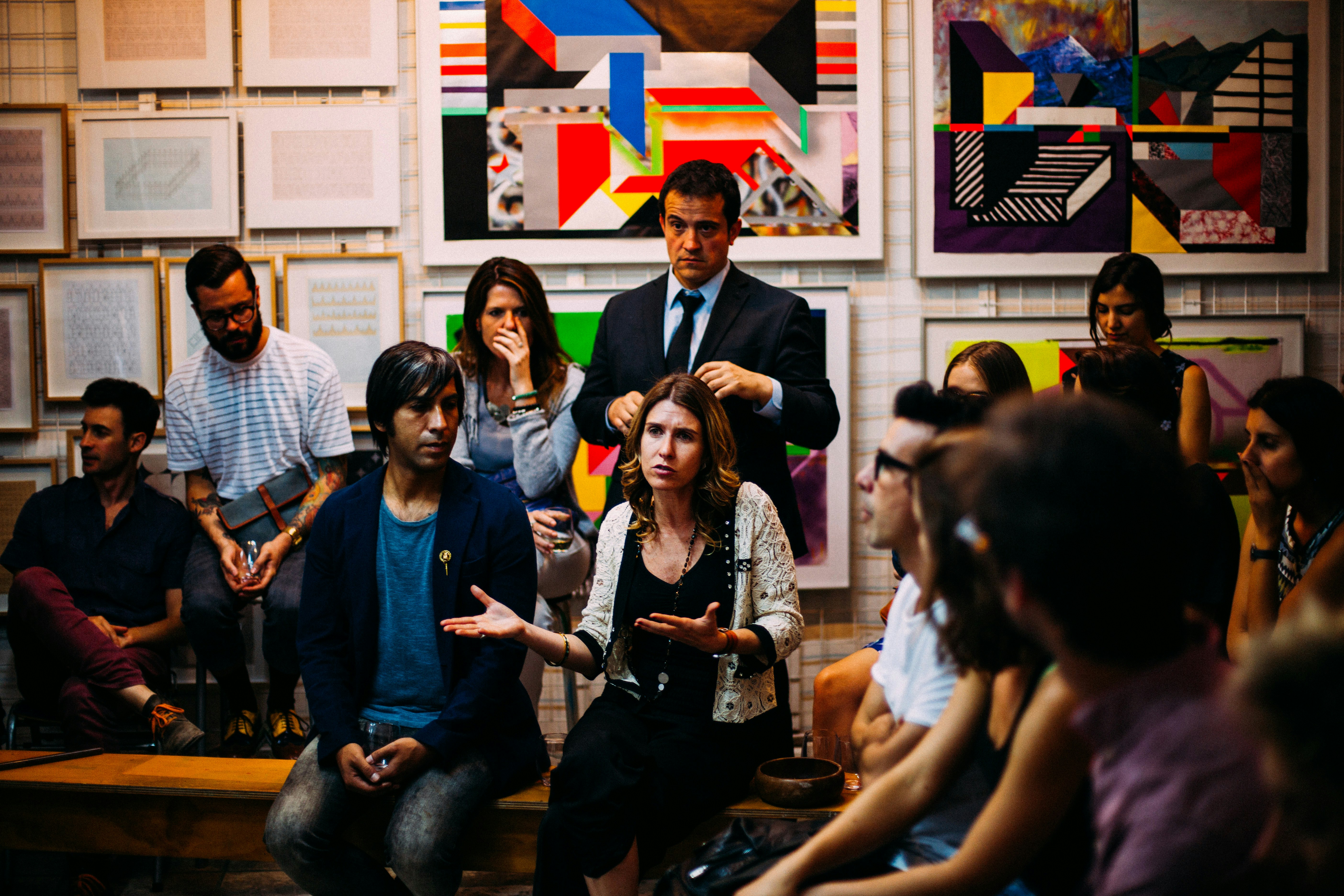 A member of an audience makes a point while gesturing.