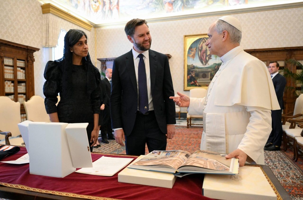 A VIP couple stand and talk with the Pope.