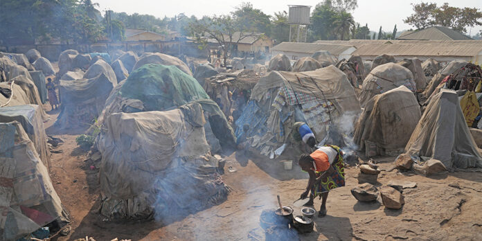 Small huts in a crowded refugee camp.