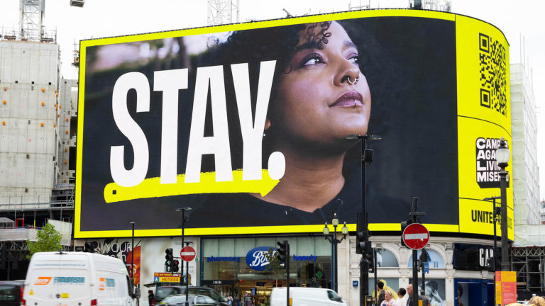 A digital billboard reads: STAY