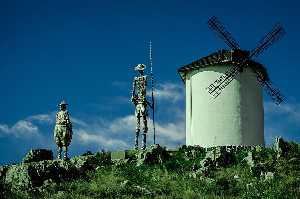 Statues of Don Quixote and Sancho Panza point toward a windmill